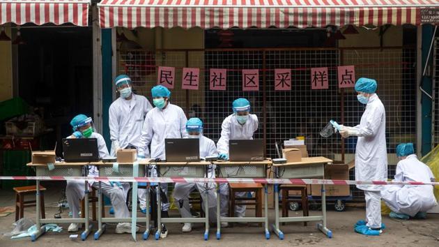 Medical workers seen at a COVID-19 testing station. The campaign to test millions is being closely watched by countries all over the world because of its scale and feasibility. Three million Wuhan residents have already been tested since April, Chinese state media reported. (STR / AFP / China OUT )
