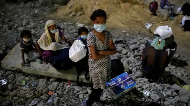 Children of migrant workers wearing protective face masks wait to cross the border to their home state of Uttar Pradesh, during an extended nationwide lockdown to slow the spread of the coronavirus disease (Covid-19), in New Delhi. (REUTERS) Children of migrant workers wearing protective face masks wait to cross the border to their home state of Uttar Pradesh, during an extended nationwide lockdown to slow the spread of the coronavirus disease (Covid-19), in New Delhi. (REUTERS)