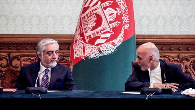 Afghan President Ashraf Ghani (R) and his rival Abdullah Abdullah (L) interact with eachother ahead of signing a power-sharing deal agreement at the Presidential Palace in Kabul.(AFP)