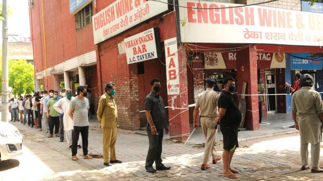 Long queue can be seen outside liquor shops in Sector 32, Chandigarh, amid the third phase of the nationwide lockdown on Monday. To prevent such crowds and queues where people forget social distancing, the Chandigarh administration is setting up a system so that people can book their liquor online and collect their order at a specified time.(Keshav Singh /HT)