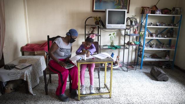 Yolanda Avila watches over her niece Sofia, a first grader, doing homework. Their home does not have an internet connection, in the Catia neighborhood of Caracas. Parents say it’s a lot of trouble, but it is the price of an education in trying times. (Ariana Cubillos / AP) Yolanda Avila watches over her niece Sofia, a first grader, doing homework. Their home does not have an internet connection, in the Catia neighborhood of Caracas. Parents say it’s a lot of trouble, but it is the price of an education in trying times. (Ariana Cubillos / AP)