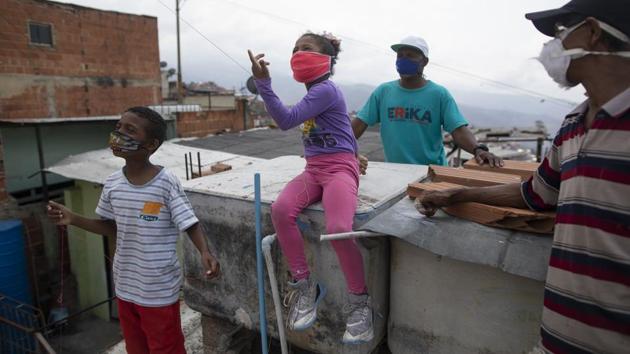 Sofia flies a kite on the rooftop of her home after finishing homework. (Ariana Cubillos / AP) Sofia flies a kite on the rooftop of her home after finishing homework. (Ariana Cubillos / AP)