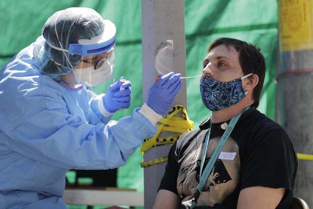 A nurse in a clinic in Seattle takes a nose swab sample from a man during walk- and drive-up testing for COVID-19. (AP) A nurse in a clinic in Seattle takes a nose swab sample from a man during walk- and drive-up testing for COVID-19. (AP)