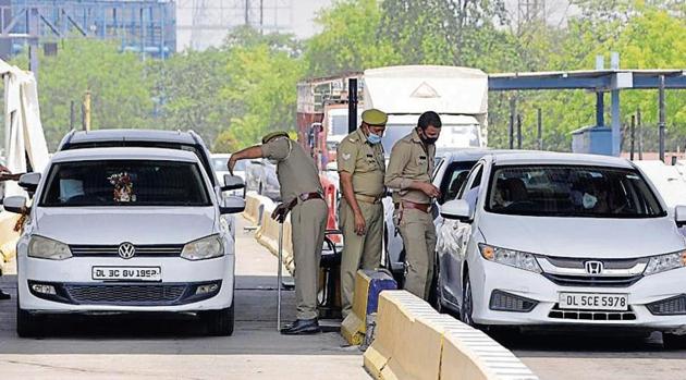 UP police personnel stop vehicles at the Uttar Pradesh-Delhi border on Monday. Gautam Budh Nagar is continuing with old guidelines and only movement of essential services and those with passes issued by the district magistrate is allowed. (Sunil Ghosh/ HT Photo) UP police personnel stop vehicles at the Uttar Pradesh-Delhi border on Monday. Gautam Budh Nagar is continuing with old guidelines and only movement of essential services and those with passes issued by the district magistrate is allowed. (Sunil Ghosh/ HT Photo)