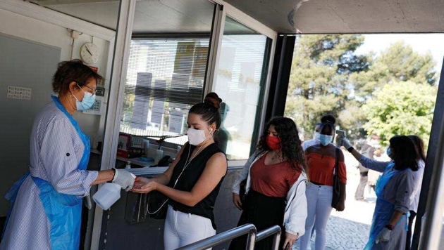 A student wearing a protective face mask uses hand sanitizer upon arrival at D. Pedro V High School, as grade 11 and 12 high school students return to schools under strict restrictions, during the coronavirus disease outbreak, in Lisbon, Portugal. (Reuters Photo ) A student wearing a protective face mask uses hand sanitizer upon arrival at D. Pedro V High School, as grade 11 and 12 high school students return to schools under strict restrictions, during the coronavirus disease outbreak, in Lisbon, Portugal. (Reuters Photo )