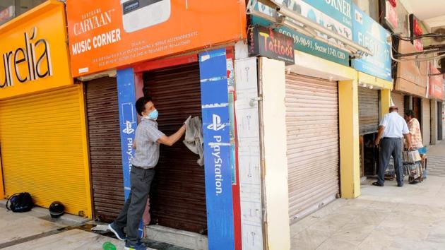 A shopkeeper in Sector 17 cleaning the shutter of his shop before it opens under relaxed norms in the fourth phase of the lockdown which comes into effect from May 18 on Monday. (Keshav Singh/HT) A shopkeeper in Sector 17 cleaning the shutter of his shop before it opens under relaxed norms in the fourth phase of the lockdown which comes into effect from May 18 on Monday. (Keshav Singh/HT)