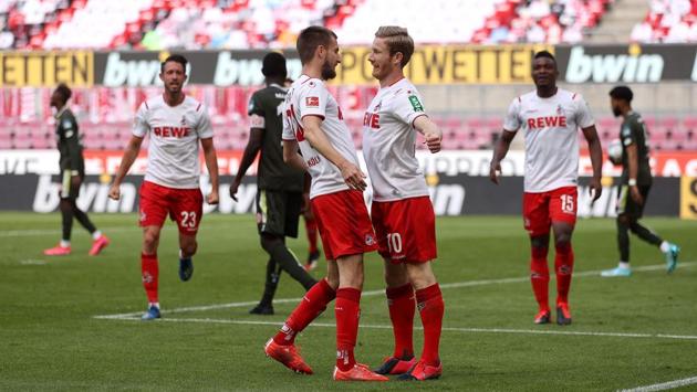 Cologne’s midfielder Florian Kainz (R) celebrates a goal with his teammate Dominick Drexler during the German first division Bundesliga football match on May 17, in Cologne. From social distancing substitutes using airport stairs to disinfected balls and a potential television audience of one billion, the German soccer’s Bundesliga enjoyed a chequered restart as the first major sports league to resume amid the pandemic. (Lars Baron / AFP)