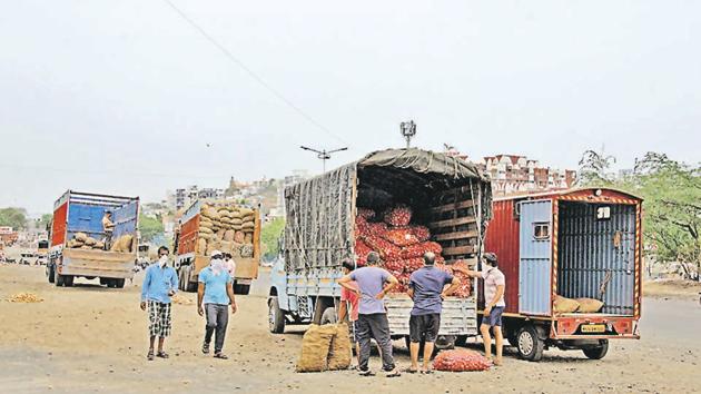 Trucks from out of town arrive at Katraj-Dehuroad bypass near Ambegaon where local retailers transfer the goods to their tempos and return to the city.(Ravindra Joshi/HT PHOTO)