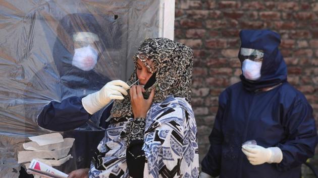 A health worker in PPE overalls takes a swab sample from a pregnant woman at a coronavirus testing centre in Srinagar, Jammu and Kashmir. (Waseem Andrabi/HT File Photo) A health worker in PPE overalls takes a swab sample from a pregnant woman at a coronavirus testing centre in Srinagar, Jammu and Kashmir. (Waseem Andrabi/HT File Photo)