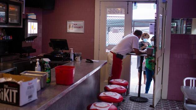 Clover Grill’s waiter Joe Congleton takes orders through an open door, keeping social distance, after restrictions of the lockdown were eased to allow 25 percent of permitted occupancy in stores and restaurants, amid the coronavirus disease (COVID-19) outbreak in New Orleans on May 16. (Kathleen Flynn / REUTERS)