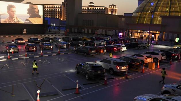 Passengers watch a movie from their car at a drive-in cinema outside the Mall of Emirates in Dubai on May 17. The governments of Abu Dhabi and Dubai are discussing ways to perk up Dubai’s economy by linking up assets in the two emirates, with Abu Dhabi’s state fund Mubadala likely to play a key role in any deal, reported Reuters. (Karim Sahib / AFP)