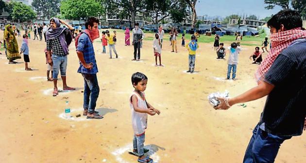 People wait to collect food in Patna on May 15.(AP Dube/HT photo)