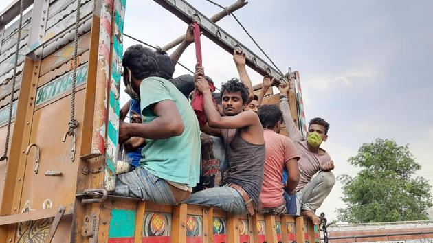 Despite the government’s efforts to arrange vehicles to transport them, the labourers can be seen moving on the road.(HT Photo)