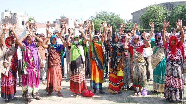 Migrant women, desperate to go back home to their states staged a protest against the Punjab government on May 18 at Court Road in Amritsar for not being able to register for the Shramik Special trains running to ferry the workers home across India. Since May 1, the railways has run 1,565 trains to send migrants stranded to their native states, carrying over 20 lakh migrants. (Sameer Sehgal / HT Photo) 