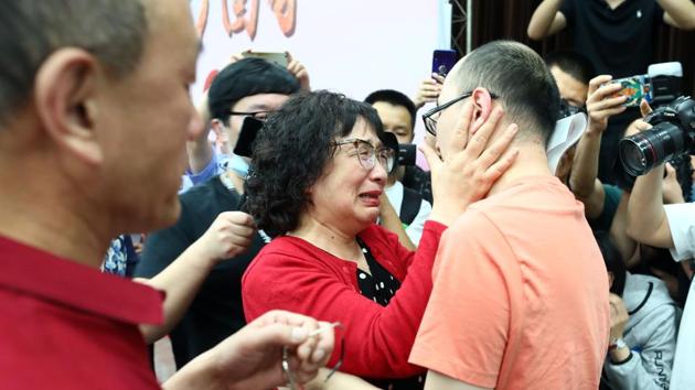 This photo taken on May 18, 2020 shows Mao Yin (R) reuniting with his mother Li Jingzhi (C) and father Mao Zhenping (L) in Xian, in China's northern Shaanxi province.(AFP)