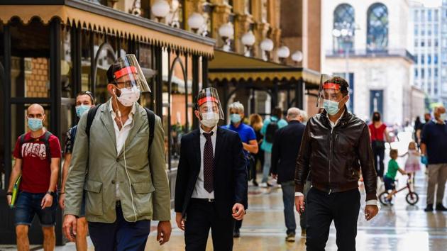 People wearing face masks and shields walk across the Vittorio Emanuele II shopping mall in Milan on May 18. Monday marked a major step forward on the road to a cautious, gradual return to normality. (Miguel Medina / AFP)