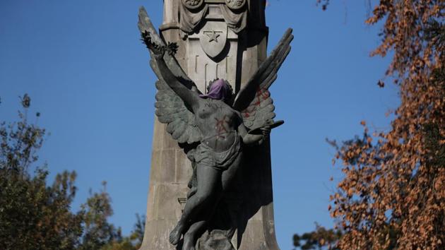 Graffiti is painted on a sculpture covered by a face mask in front of the Museo Nacional de Bellas Artes (National Fine Arts Museum). Santiago is one of Latin America´s most prosperous cities, but a stark rich-poor divide and a growing sense of inequality prompted mass protests in late 2019. (Ivan Alvarado / REUTERS)
