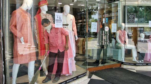 A person cleans the front of a store’s product display in New Delhi on May 19. All shops in marketplaces can open from today onwards, but on the basis of an odd-even pattern similar to the one implemented for traffic management on occasion. (ANI)