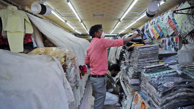 A shopkeeper wearing a protective mask cleans his shop while opening for business in old Delhi on May 19. Almost all major markets such as Connaught Place, Sarojini Nagar, Lajpat Nagar, Greater Kailash-I and Kamala Nagar Market, among others, have decided to reopen shops from today. (Prabhat Mehrotra / ANI)