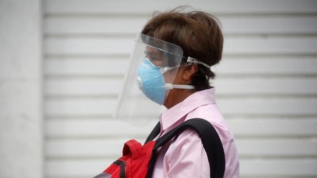 A man wearing a face mask and a face shield waits for a bus before repatriation flights bound for Canada organized by the Canadian embassy. (REUTERS) A man wearing a face mask and a face shield waits for a bus before repatriation flights bound for Canada organized by the Canadian embassy. (REUTERS)