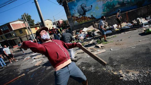 Demonstrators clash with riot police during a protest against the Chilean government amid the COVID-19 pandemic in Santiago on May 18. The protest erupted due to shortages in food and employment in one of the Chilean capital´s poorest neighbourhoods. (Pablo Rojas / AFP)