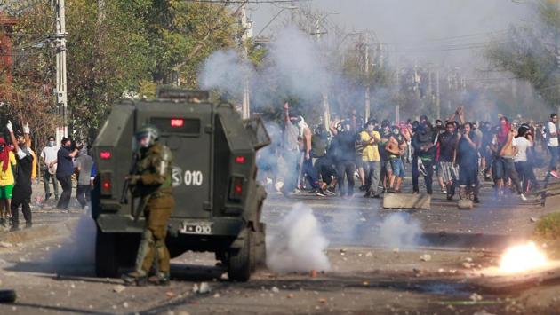 A group of protesters threw rocks, shouted and burned piles of wood along a street in the destitute neighbourhood on Santiago’s southern fringe. (Pablo Rojas / AFP)