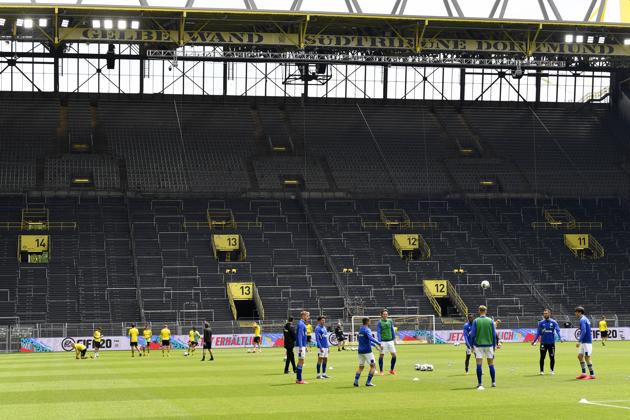 Dortmund, left, and Schalke players exercise during warmup before the German Bundesliga soccer match between Borussia Dortmund and Schalke 04 in Dortmund, Germany. (AP)