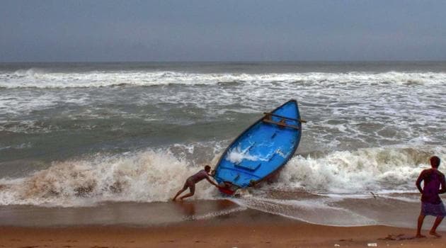Puri: Fishermen try to control their boat amidst rough sea waters ahead of the landfall of Cyclone Amphan at Puri beach on Tuesday. (PTI File Photo) Puri: Fishermen try to control their boat amidst rough sea waters ahead of the landfall of Cyclone Amphan at Puri beach on Tuesday. (PTI File Photo)