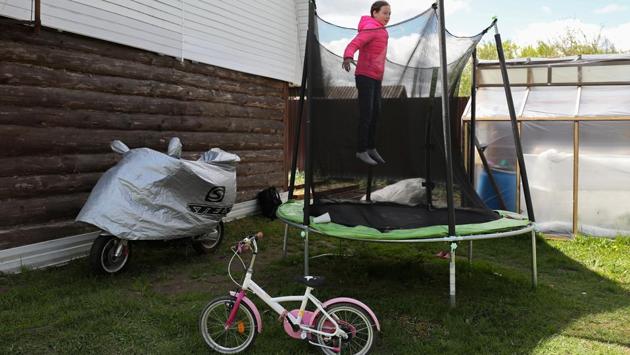 Alyona Vinogradova jumps on a trampoline as she self-isolates with her family at their dacha or country house amid the outbreak in Moscow on May 19. Russian health officials say one of the reasons the count is lower than in the United States and parts of western Europe is that only deaths directly caused by the virus are being included. (Evgenia Novozhenina / REUTERS)