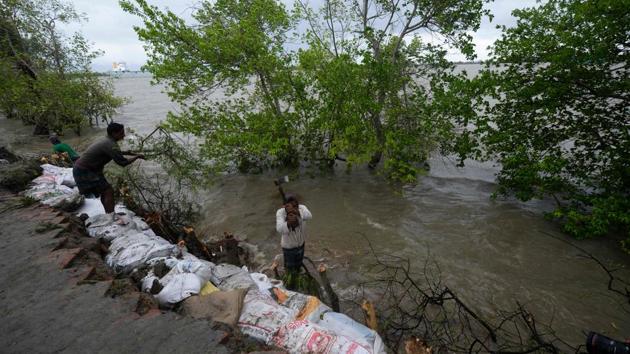 Villagers reinforce an embankment with sacks of soil just ahead of the expected landfall of cyclone Amphan in Dacope on May 20 in Bangladesh. Amphan is expected to move further into Bangladesh on May 21 and later Bhutan. (Munir Uz Zaman / AFP)