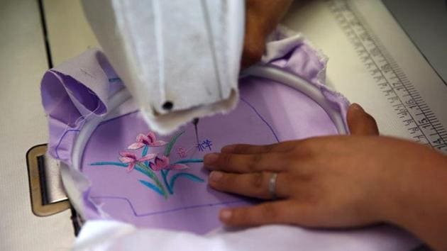 A worker uses a sewing machine to embroider Chinese characters "Ji Xiang", symbolising good luck, on a piece of silk cloth for making a face mask designed by Zhou Li, at a studio in Beijing, following the novel coronavirus disease (COVID-19) outbreak, China May 17, 2020. Picture taken May 17, 2020. REUTERS/Tingshu Wang (REUTERS) A worker uses a sewing machine to embroider Chinese characters "Ji Xiang", symbolising good luck, on a piece of silk cloth for making a face mask designed by Zhou Li, at a studio in Beijing, following the novel coronavirus disease (COVID-19) outbreak, China May 17, 2020. Picture taken May 17, 2020. REUTERS/Tingshu Wang (REUTERS)