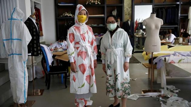 Designer Zhou Li and Ni Zan'er in protective suits and silk face masks designed by Zhou, pose for pictures at a studio in Beijing, following the novel coronavirus disease (COVID-19) outbreak, China May 17, 2020. Picture taken May 17, 2020. REUTERS/Tingshu Wang (REUTERS) Designer Zhou Li and Ni Zan'er in protective suits and silk face masks designed by Zhou, pose for pictures at a studio in Beijing, following the novel coronavirus disease (COVID-19) outbreak, China May 17, 2020. Picture taken May 17, 2020. REUTERS/Tingshu Wang (REUTERS)