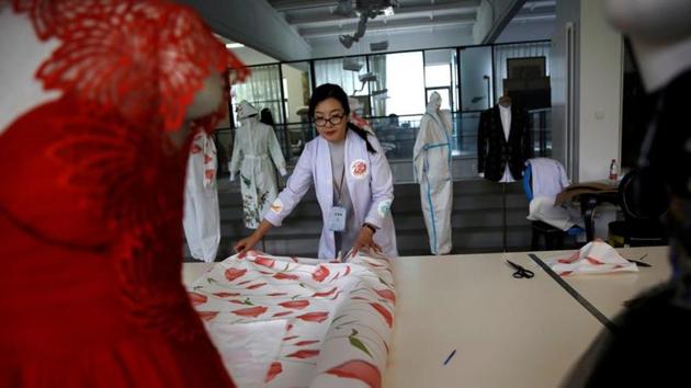Designer Zhou Li spreads out PPE cloth used for making her designed protective suits, at a studio in Beijing, following the novel coronavirus disease (COVID-19) outbreak, China May 17, 2020. Picture taken May 17, 2020. REUTERS/Tingshu Wang (REUTERS) Designer Zhou Li spreads out PPE cloth used for making her designed protective suits, at a studio in Beijing, following the novel coronavirus disease (COVID-19) outbreak, China May 17, 2020. Picture taken May 17, 2020. REUTERS/Tingshu Wang (REUTERS)