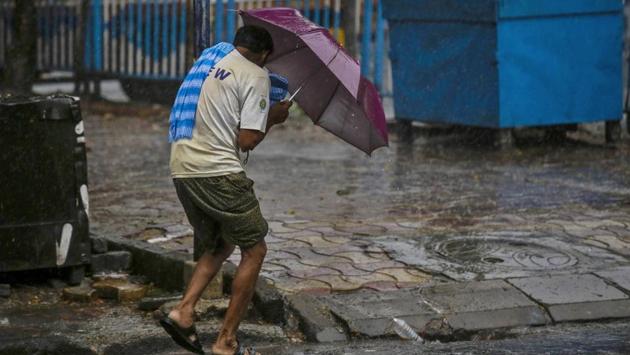 A man struggles to hold his umbrella and walk in Kolkata on May 20 as severe cyclonic storm Amphan makes landfall along the coastline of India and Bangladesh. (Bikas Das / AP)