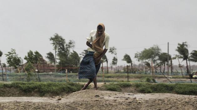 A man walks against the force of the wind in Bhadrak district, Odisha on May 20. The landfall process has triggered intense rain and gusty winds and will continue for about four hours, according to the India Meteorological Department (IMD). (AP)