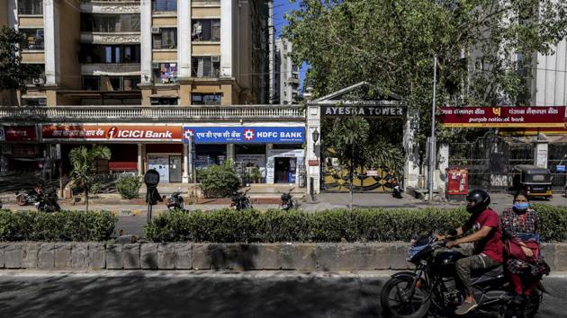 A motorcyclist and passenger travel past branches of ICICI Bank Ltd., HDFC Bank Ltd. and Punjab National Bank (PNB) on a near-empty street in Mumbai. (Bloomberg) A motorcyclist and passenger travel past branches of ICICI Bank Ltd., HDFC Bank Ltd. and Punjab National Bank (PNB) on a near-empty street in Mumbai. (Bloomberg)