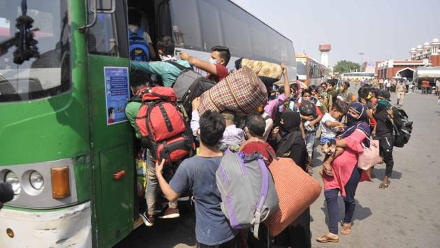 Migrants rush to fill Uttar Pradesh state government buses ferrying them home, while flouting social distancing at Charbagh Railway Station in Lucknow on May 18.   (Deepak Gupta / HT Photo) 