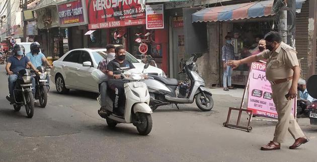 Police issuing challans to two-wheeler riders for violating lockdown orders in Ludhiana on Tuesday. (Gurpreet Singh/HT) Police issuing challans to two-wheeler riders for violating lockdown orders in Ludhiana on Tuesday. (Gurpreet Singh/HT)