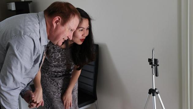 Groom Peter Andrews and bride Hoang Nguyen use a video call to speak with loved ones unable to attend their wedding ceremony due to the coronavirus disease (COVID-19) travel restrictions, just before getting married at home in Sydney, Australia, May 19, 2020. REUTERS/Loren Elliott (REUTERS)