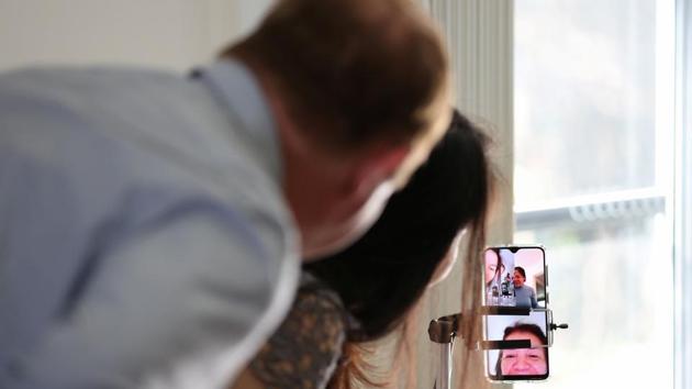 Groom Peter Andrews and bride Hoang Nguyen use a video call to speak with loved ones unable to attend their wedding ceremony due to the coronavirus disease (COVID-19) travel restrictions, just before getting married at home in Sydney, Australia, May 19, 2020. REUTERS/Loren Elliott (REUTERS)