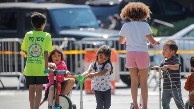 Children play while families wait in line at a food bank at St. Bartholomew Church, during the outbreak of the coronavirus disease in the Elmhurst section of Queens, New York City, New York, US.(REUTERS)