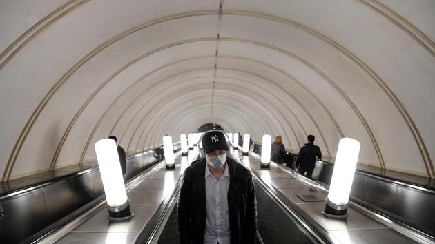 A man wearing a face mask rides an escalator at Park Kultury metro station in downtown Moscow on May 20. Wearing face masks and latex gloves is mandatory for people using Moscow’s public transport. (Kirill Kudryavtsev / AFP)