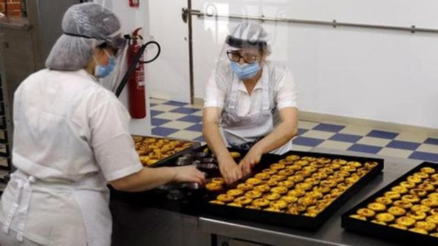 Women wearing protective masks work at custard tart shop Pasteis de Belem, as restaurants, museums and coffee shops reopen at reduced capacity, during the coronavirus disease (COVID-19) outbreak, in Lisbon, Portugal May 18, 2020. REUTERS/Rafael Marchante(REUTERS)