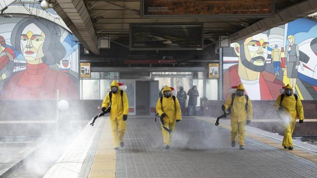 Employees of the Federal State Center for Special Risk Rescue Operations of Russia Emergency Situations disinfect a platform of Leningradsky railway station in Moscow on May 19. (Pavel Golovkin / AP)