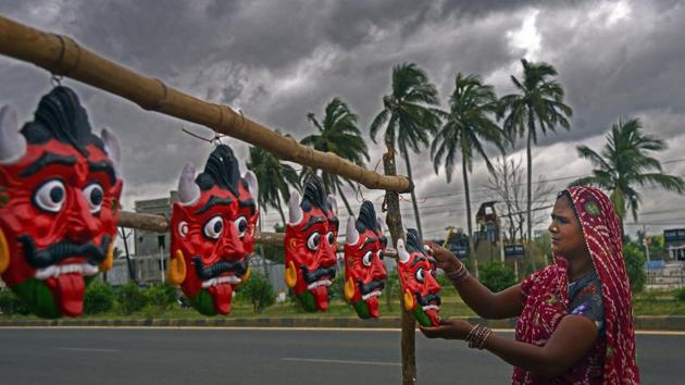 A woman hangs clay demon masks by the roadside as dark clouds gather ahead of Cyclone Amphan’s landfall, on the outskirts of Bhubaneswar on May 19. Indian Meteorological Department (IMD) officials said coastal towns such as Chandbali, Balasore, and Bhubaneswar are experiencing high wind speed. (PTI) A woman hangs clay demon masks by the roadside as dark clouds gather ahead of Cyclone Amphan’s landfall, on the outskirts of Bhubaneswar on May 19. Indian Meteorological Department (IMD) officials said coastal towns such as Chandbali, Balasore, and Bhubaneswar are experiencing high wind speed. (PTI)