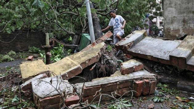 A man walks over a collapsed wall in Kolkata on May 21. “We are facing three crises: the coronavirus, the thousands of migrants who are returning home and now the cyclone,” said West Bengal Chief Minister Mamata Banerjee. (Rupak De Chowdhuri / REUTERS)