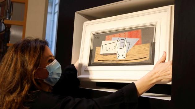 Raffle organizer Peri Cochin, wearing a protective face mask, poses with the painting "Nature Morte, 1921" by Spanish painter Pablo Picasso after the charity raffle official draw to designate the winner of the Picasso oil painting for 100 euros at Christie's auction house in Paris, May 20, 2020. REUTERS/Charles Platiau(REUTERS) Raffle organizer Peri Cochin, wearing a protective face mask, poses with the painting "Nature Morte, 1921" by Spanish painter Pablo Picasso after the charity raffle official draw to designate the winner of the Picasso oil painting for 100 euros at Christie's auction house in Paris, May 20, 2020. REUTERS/Charles Platiau(REUTERS)