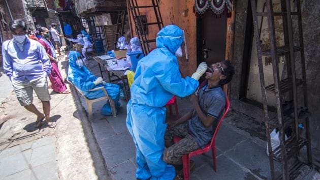 A doctor takes a swab sample of a resident at a COVID-19 coronavirus testing drive inside the Dharavi slums during a government-imposed nationwide lockdown as a preventive measure against the spread of the COVID-19 coronavirus in Mumbai, India, on Wednesday, May 20, 2020. (Pratik Chorge/HT Photo)