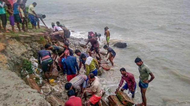 Villagers repair a bank that was destroyed by waves at Bakkhali due to the landing of Cyclone Amphan, near Sunderbans area in South 24 Parganas district of West Bengal on May 20. While 12 people have been killed in West Bengal, nine have been reported dead in neighbouring Bangladesh. (PTI)