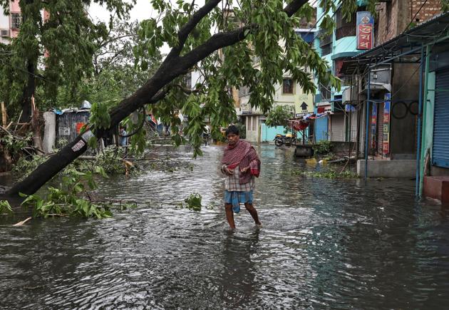 A man crosses a flooded street after Cyclone Amphan, Kolkata, May 21, 2020 (REUTERS)